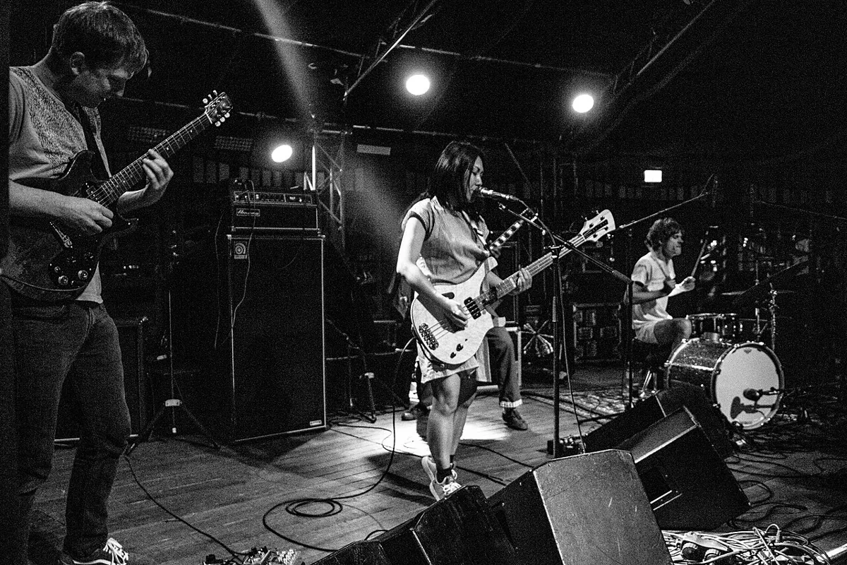 Deerhoof performing live in an archival photograph